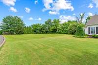 This is a view from the front yard showing that the property extends all the way to the stone fence of the entrance