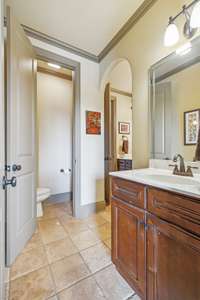 Jack&Jill bath for bedrooms 3 and 4 has tile flooring and custom cabinetry