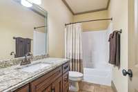Private bath for bedroom #2 features custom cabinetry and granite countertops