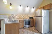 apartment kitchen with full size stove and refrigerator.
