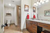 2nd full bath in basement suite features tile floor/shower, granite countertops and custom cabinetry.