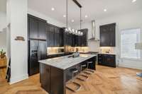 The 2nd level of the home features a refined chef's kitchen with an expansive island and abundance of cabinets.