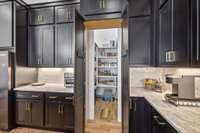 Hidden behind a facade of cabinets is a deep walk in pantry for food storage and hidden appliances such as a microwave.