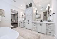 Indulge in the spa-like en suite bathroom, complete with a large walk-in tiled shower, soaking tub, dual quartz vanities, and exquisite finishes that create a calming, rejuvenating atmosphere.