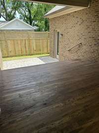 Lovely covered porch with ceiling fan and recessed lighting with pavered patio below and 8' privacy fence.