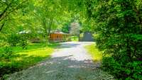 Primary gravel driveway with tree canopy welcoming you home