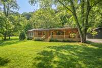 Relax on your porch and listen to the peaceful babbling creek bordering the front and side of property.