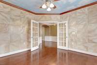 Office with French doors. The walls appear to be tiled. However, the walls are painted by a professional to look like tile.