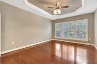 Master bedroom with tray ceiling and ceiling fan.
