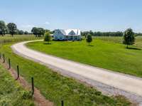 A lengthy concrete driveway guides you to the ideally positioned home.