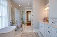 En-suite Bathroom features quartz countertops and custom wood cabinetry with a separate soaking tub and a spacious shower for a spa experience.