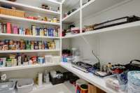 Spacious walk-in Pantry featuring wooden shelving designed for optimal organization.