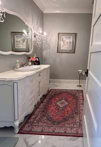 The Bathroom's standout feature is a custom vanity crafted from an antique dresser, adding character and warmth to the room. Its original matching antique mirror is perfectly preserved and thoughtfully integrated into the design.