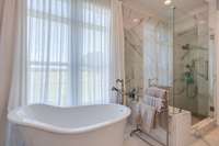 The freestanding soaking tub is sleek and elegant, with smooth, flowing curves and a deep basin designed for ultimate relaxation.