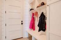 Just off the Garage, the mudroom features a custom-built bench, offering a practical and stylish space to organize everyday essentials.