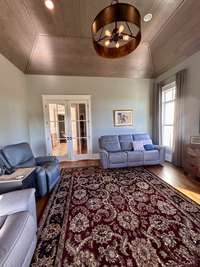 The room features a stunning, paneled wood ceiling crafted in an elegant turtle back design, adding architectural interest and a warm, rustic touch to the space.