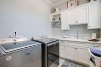 The Laundry Room is a luxurious space, measuring 7X13, complete with a sleek sink and custom cabinetry for an elegant and functional design.