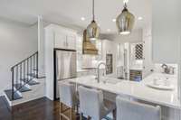 Renovated kitchen with quartz countertops, wine fridge, and double ovens