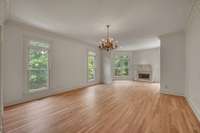 Primary bedroom features a spacious area that has a cozy sitting area with gas fireplace (overlooking the backyard) elegant chandelier, crown molding and en suite primary bathroom
