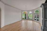 Dining room features beautiful crown molding, elegant chandelier, large windows, and its adjacent to the butlers pantry leading to the kitchen
