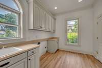 Laundry room is right off the kitchen and has tons of cabinets, sink, and closet