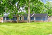 Beautiful one level home surrounded by storybook trees.