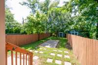 Sleek and low maintenance backyard that is fully fenced in with a privacy fence. The yard has a central patio that is great for a fire pit and lounging furniture.
