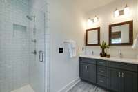 Another pocket door leads you to the spa-worthy sun-kissed primary bathroom, complete with a double vanity and a large walk-in shower with a frameless glass door.