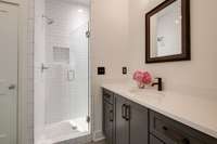 The ensuite bath on the main level has a lovely shower with a frameless glass shower door, a linen closet and a great vanity with ample storage!