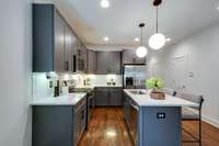 The chef worthy kitchen features ample cabinetry, generous counter space, under-cabinet lighting, and a sleek gas range.