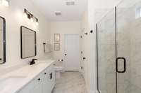 This luxurious bathroom includes raised quartz counters, new faucets, new mirrors, lighting , tile flooring and a tile shower.