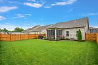 A privacy fence encloses the yard, providing a secure space for kids or pets to play and for adults to relax in peace.