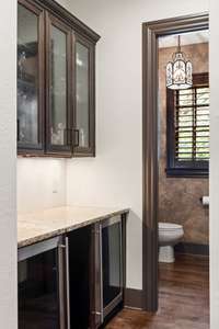 Double beverage fridge at the bar off the kitchen. Half bath beyond.