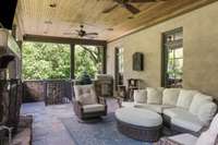 Alternative view of main floor porch. The staircase in the background takes you to the ground level covered patio that has a another two-sided fireplace and ideal covered party spot next to the future pool.