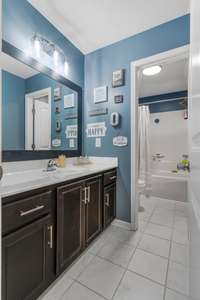Upstairs full bathroom with double sinks and a separate toilet room with tub shower combo.