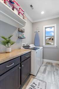 Oversized laundry room with cabinetry and counter top perfect for keeping things organized and giving you a folding area.