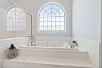 Master bath with 16-ft ceilings, large walk-in shower with two shower heads, body sprayers and large bench, jacuzzi tub, water closet, and heated tile floors