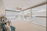 Loft area that overlooks living room. Flex space - currently being used as a reading area.
