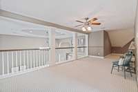 Loft area that overlooks living room. Flex space - currently being used as a reading area.