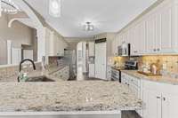 Granite countertops, stainless steel appliances, double oven, under cabinet lighting, and heated tile floors. Central vac system throughout.