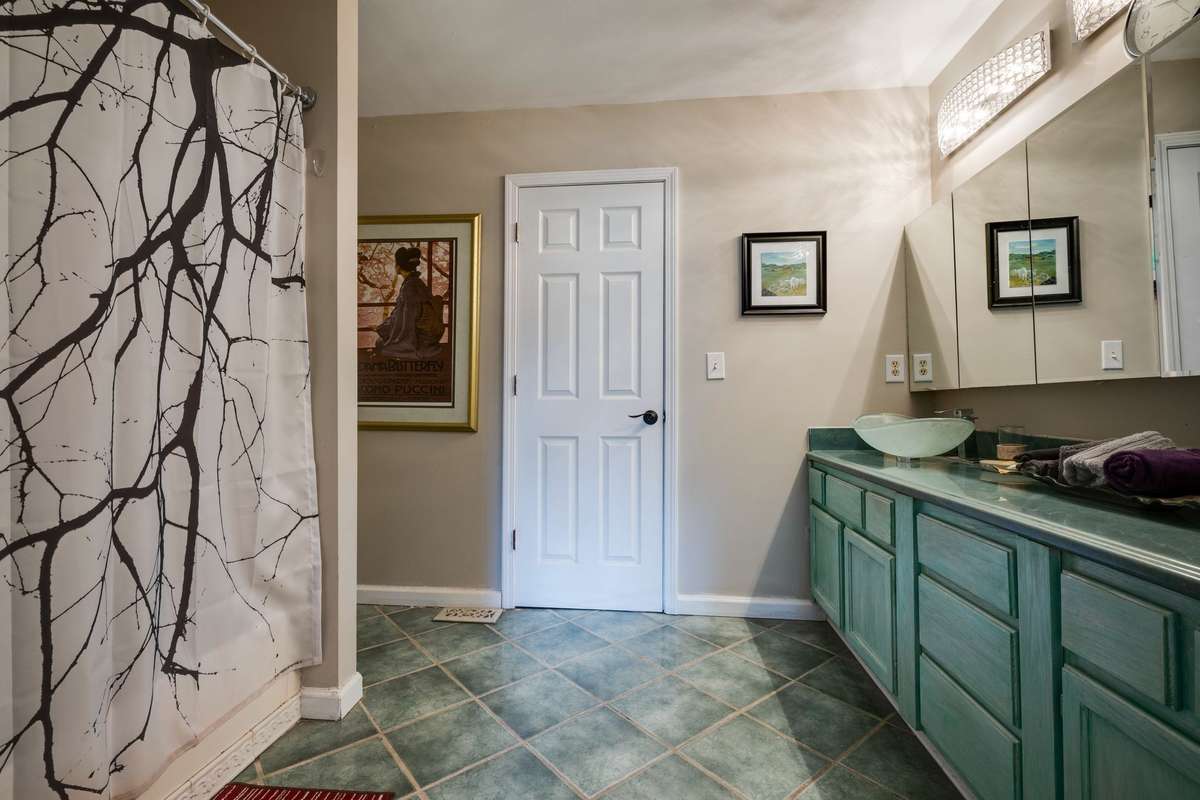 Shower/bath and double sinks and ceramic tile in bathroom of Barndominium.