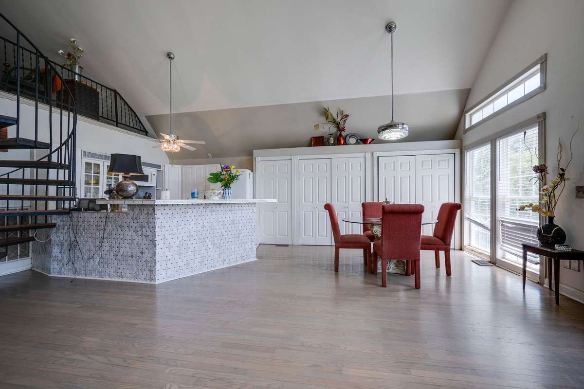 Eating area, kitchen, and storage cabinets. Lots of light shinning in through the door, transoms, etc.