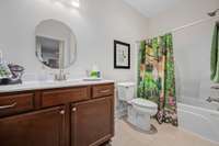 Full bath located between the 2nd and 3rd bedroom.  Artisan tile flooring, marble sink top, and a shower/tub combo
