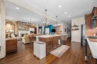 Alternate view of this open kitchen with a large island, plenty of cabinets, pull out drawers, with a separate breakfast area.