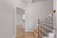 Staircase to upstairs features hardwood treads, tread lights, wrought iron spindles.