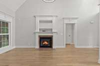 Fireplace features tile surround, gas logs, custom mantel and over-mantel.