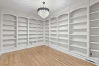 Study/Library located off of kitchen features French doors and custom bookcases
