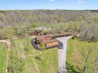Overview of the side of the Main lodge in the middle of the photo, venue on the creek in top of photo ad outdoor pavillion/parking