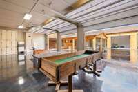 Game room/Armory area in Main Lodge with full garage door pull ups for open air entertainment to the outside bar/lounge area