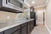 Basement kitchenette has plenty of cabinet space, a full size fridge, and a microwave